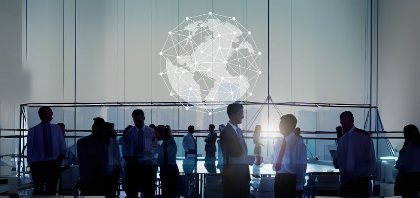 Empresários em reunião internacional com conexão global ao fundo, simbolizando a internacionalização de empresas brasileiras para Portugal em 2025